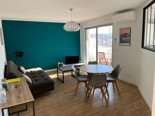 a living room with a table and a couch at T2 55m2 Perpignan proche centre ville et gare avec parking in Perpignan