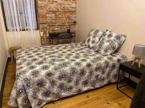 Un dormitorio con una cama con una manta. en Appartement plein centre en Toulouse