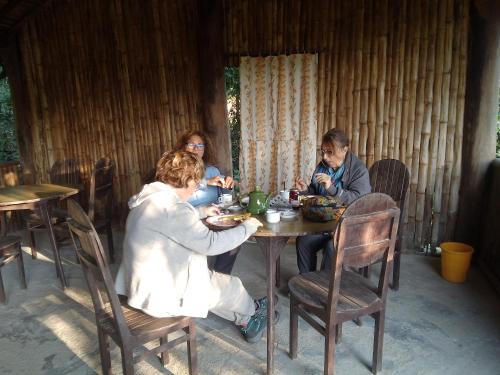een groep mensen die aan een tafel zitten te eten bij Jungle Base Camp in Bardiyā