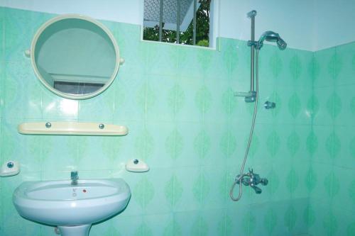 een badkamer met een wastafel en een spiegel bij Hikkaduwa White Villa near to beach with 3 bedroom in Galle