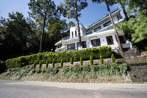 a white house on the side of a road at The Golden Sunrise Hotel in Nainital