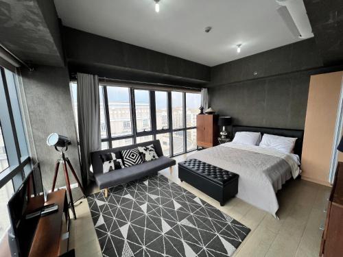 een slaapkamer met een kingsize bed en een bank bij Modern Studio at NAIA Terminal 3 in Manilla