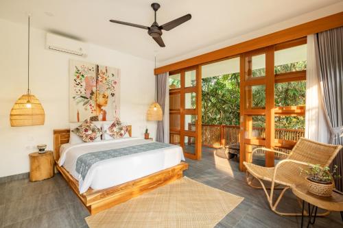 ein Schlafzimmer mit einem Bett und einem Balkon in der Unterkunft Villa Nya Ubud in Ubud