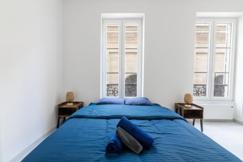 a bedroom with a blue bed with blue pillows at Luxurious 2 Bedroom Avenue des Champs-Élysées Saint-Philippe du Roule Free Netflix in Paris