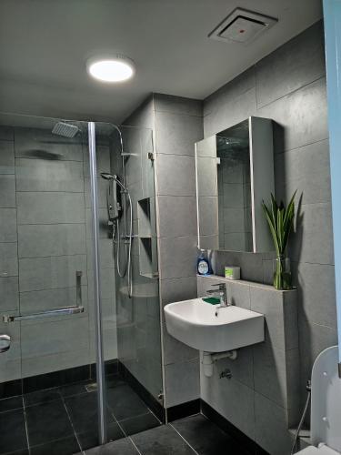 uma casa de banho com um lavatório e um chuveiro em ArasTwo JQ Homestaykk LEVEL 22 SEAVIEW em Kota Kinabalu