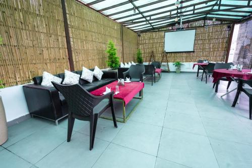 a restaurant with tables and chairs and a projection screen at The Golden Sunrise Hotel in Nainital