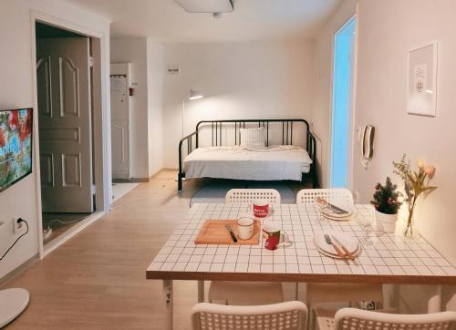 a living room with a table and a bed at J-Stay near Hongdae in Seoul