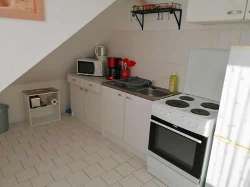eine kleine Küche mit einem Herd und einer Mikrowelle in der Unterkunft Apartment Irina in Pirmasens