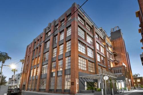 a tall red brick building on a city street at Chic Urban Loft in Prime Location in Melbourne