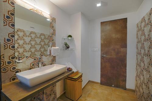 y baño con lavabo y espejo. en SaffronStays Moringa Valley Ashoka Villa, en Udaipur