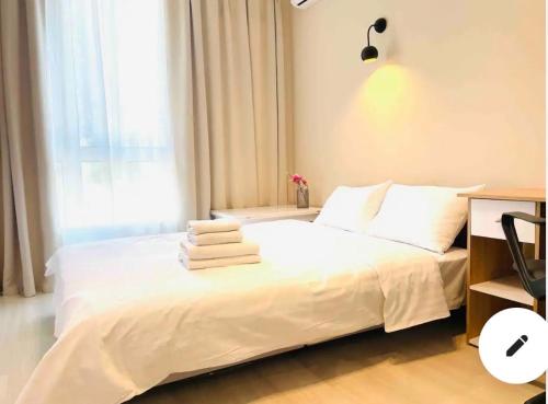 Un dormitorio con una cama blanca con toallas. en Mira Apart-Hotel, en Kiev