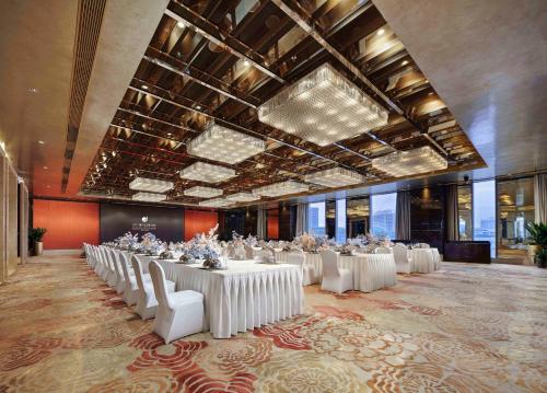 a banquet hall with white tables and white chairs at Sanding New Century Grand Hotel Yiwu in Yiwu