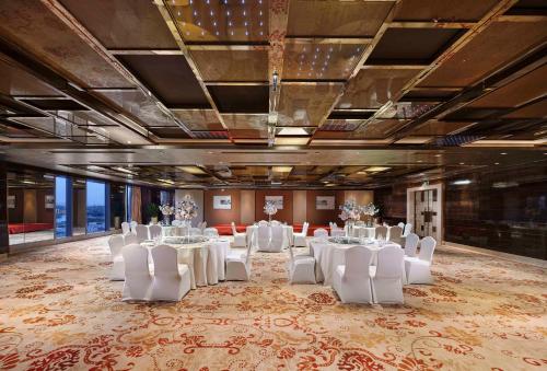 a banquet hall with white tables and white chairs at Sanding New Century Grand Hotel Yiwu in Yiwu