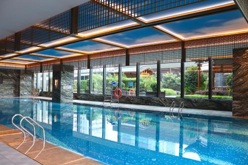 a large swimming pool in a building with windows at JW Marriott Hotel Xi'an Southwest in Xi'an