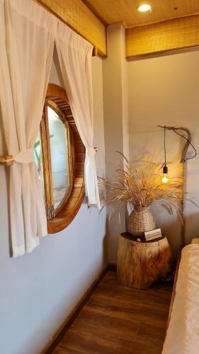 a bedroom with a window and a table with a plant at TỊNH Retreat Phu Quoc in Phu Quoc