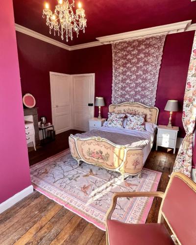 Schlafzimmer mit einem Bett mit lila Wänden und einem Kronleuchter in der Unterkunft Maison de Mags & Mags Marie Antoinette Room in Lanouaille