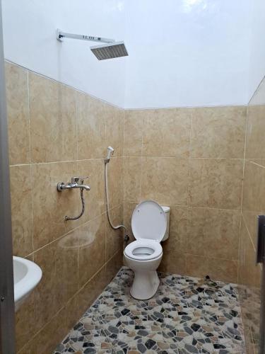 a bathroom with a toilet and a shower at Kresna Guest House Syariah Pacitan in Pacitan