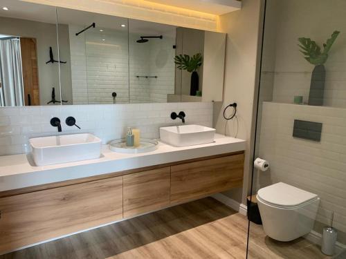 a bathroom with two sinks and a toilet and a mirror at Dockside 1106 in Cape Town