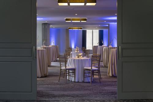 a room filled with tables and chairs with purple lighting at Le Meridien New Orleans in New Orleans