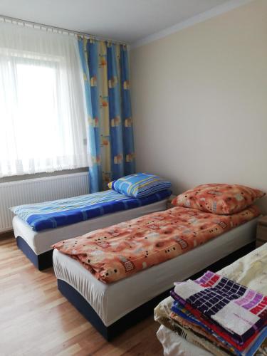 1 dormitorio con 2 camas y ventana en Przystań Przylasek en Cracovia