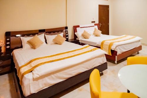 - 2 lits dans une chambre avec une table et des chaises dans l'établissement Ekefaru Inn, à Viligili