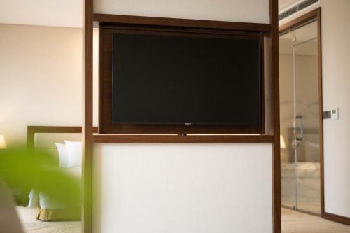 a flat screen tv sitting on top of a wall at Muong Thanh Luxury Cao Bang in Cao Bằng