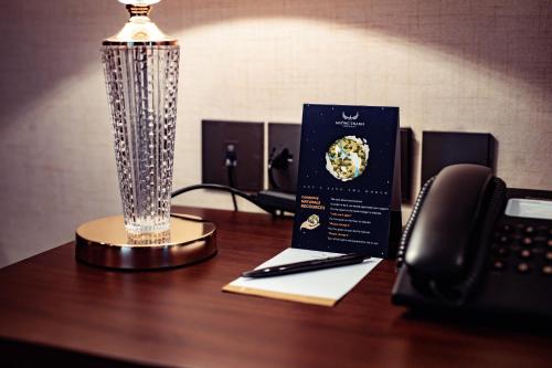 a desk with a phone and a trophy on a table at Muong Thanh Luxury Cao Bang in Cao Bằng