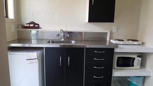 a kitchen with a sink and a microwave at Ruapehu Mountain Motel & Lodge in Ohakune