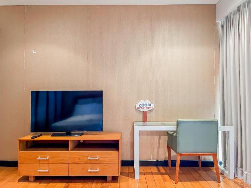 a living room with a tv and a desk with a chair at The Sea Luxury Nha Trang Apartment in Nha Trang