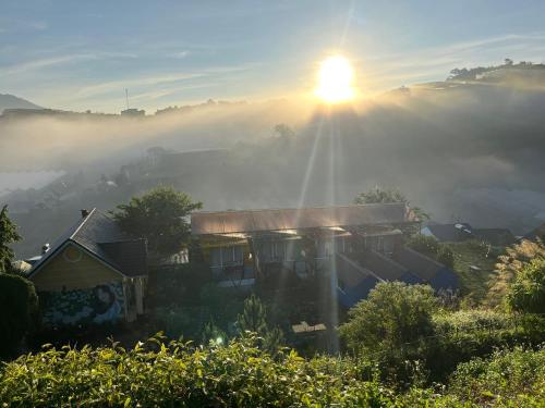 大叻的住宿－Nhà Trong Sương Đà Lạt，雾中的一个房子,太阳从后面升起