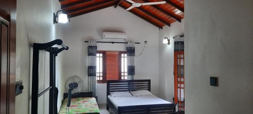 - une chambre avec un lit dans une pièce dotée d'une fenêtre dans l'établissement New White House Ratnapura, à Ratnapura