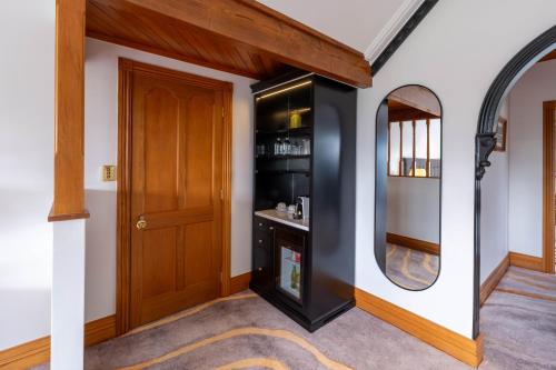 a hallway with a door and a mirror at Hana Lodge in Rotorua