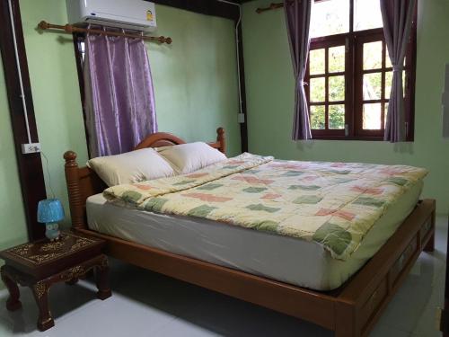 a bedroom with a bed with a quilt on it at The Orange House Thailand - Baan P'Nae Homestay in Ban Khlong Bang Khrok