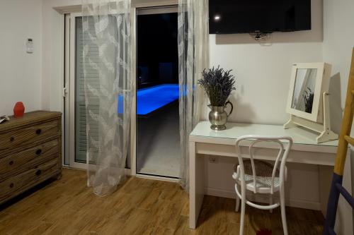 a bedroom with a desk and a chair and a window at Vila Gallo in Galovac