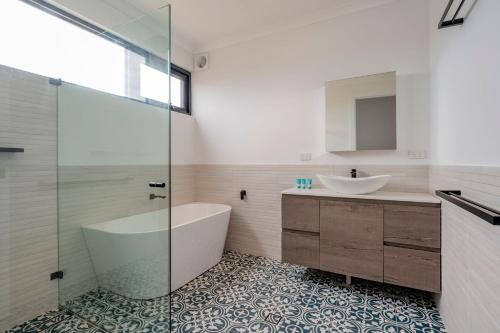 y baño con bañera y lavamanos. en Port Lane Lower Apartment en Geographe