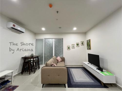 uma sala de estar com um sofá e uma televisão em The Shore Kota Kinabalu by Ariana em Kota Kinabalu