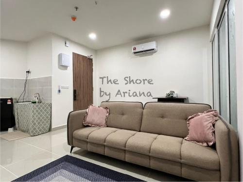 a couch in a living room with a sign on the wall at The Shore Kota Kinabalu by Ariana in Kota Kinabalu