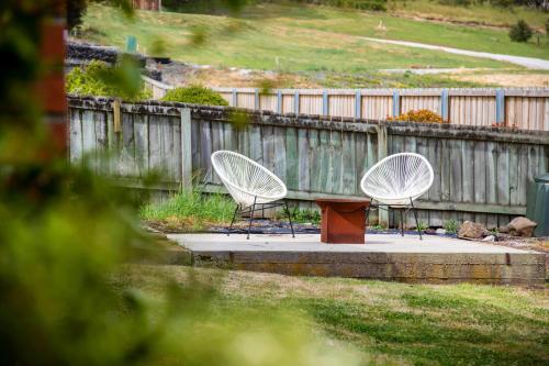 two chairs and a table in front of a fence at Stunning Ocean View Perfect For Groups & Families in Cooee