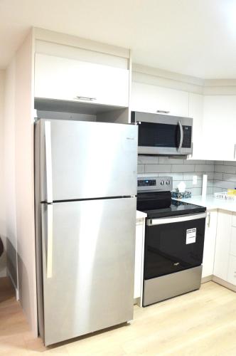 a kitchen with a refrigerator and a stove at Secondary Suite, Separate Entrance NW Calgary in Calgary