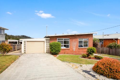 a brick house with a garage in a yard at Stunning Ocean View Perfect For Groups & Families in Cooee