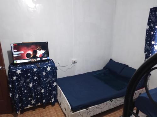 a bedroom with a bed with a laptop on it at Mines and Wright Transient in Baguio