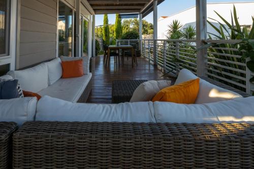 a screened porch with white couches and a table at Vila Gallo in Galovac