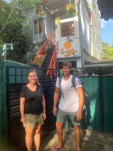 a man and a woman standing in front of a building at The Orange House Weligama in Matara