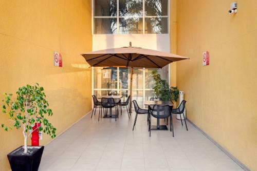 a restaurant with tables and chairs with an umbrella at City Express by Marriott Tepotzotlán in Tepotzotlán