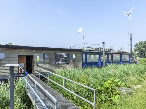 a building with a ramp leading to a pier at Cushy Boat in Merkem with Terrace in Drie Grachten