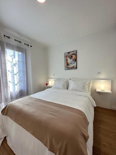 um quarto com uma grande cama branca e uma janela em Madeiran Sweet Home no Funchal