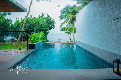 a swimming pool with a view of the ocean at LA RÊVE The Beach Villa in Malappuram