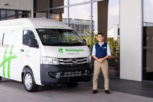 a man standing in front of a white van at Holiday Inn Sepang - Airport in Sepang