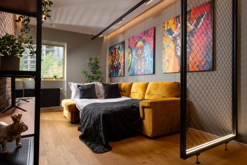 sala de estar con sofá amarillo y algunas pinturas en Brooklyn Studio - Aviatiei Park - Netflix - Parking, en Bucarest