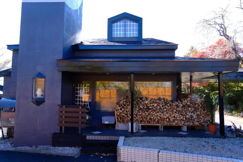 a house with a pile of fire wood in it at LCO-Resort in Takizawa